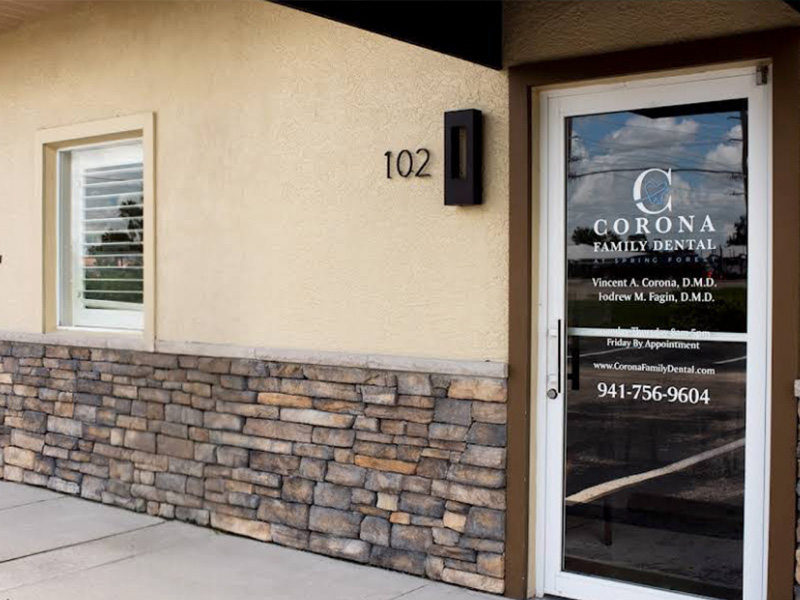 The image shows a real estate office with a sign that reads  CORONA FAMILY DENTAL  on the door, indicating the name of the business operating within the building.