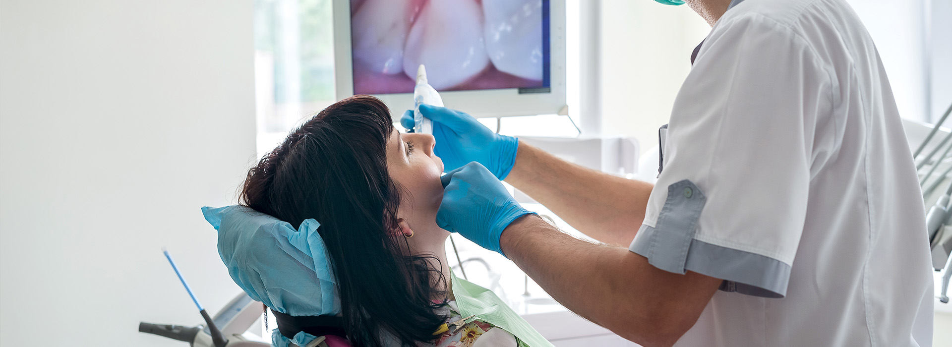 A dental professional assisting a patient during a dental appointment.