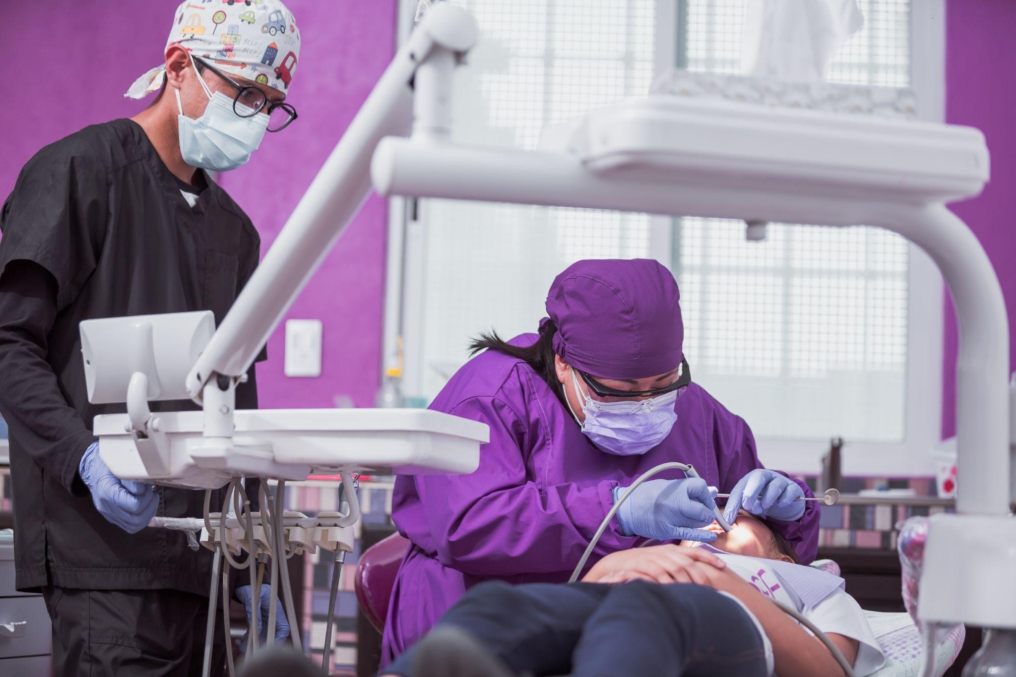 Dentist performing restorative dental treatment on a patient in a modern clinic, showcasing dental restorative services in a supportive and professional environment.