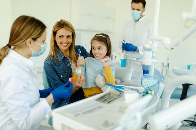 Mother and daughter seeing a dentist in a family health dental clinic.
