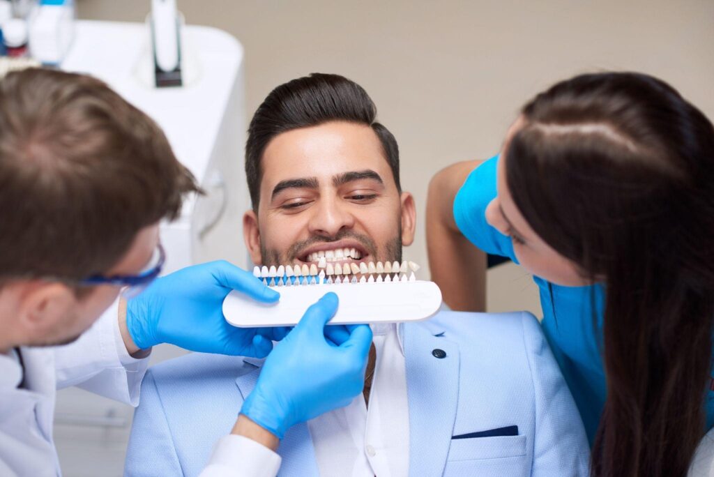 Patient consulting with a cosmetic dentist in Bradenton while comparing veneer and whitening shades for a brighter smile.